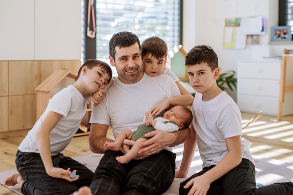 Portrait of a father and his four sons, holding his newborn baby.