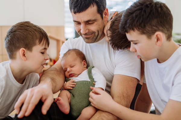 Portrait of a father and his four sons, holding his newborn baby.