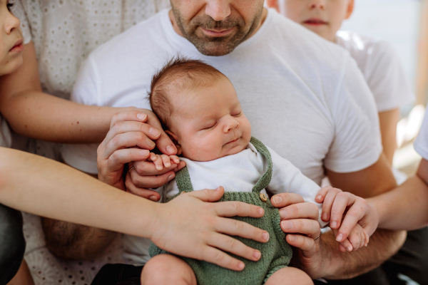 Big family with four sons enjoying their newborn baby.