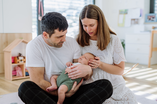 Happy parents cuddling with their newborn son.