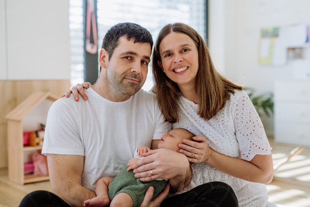 Happy parents cuddling with their newborn son.