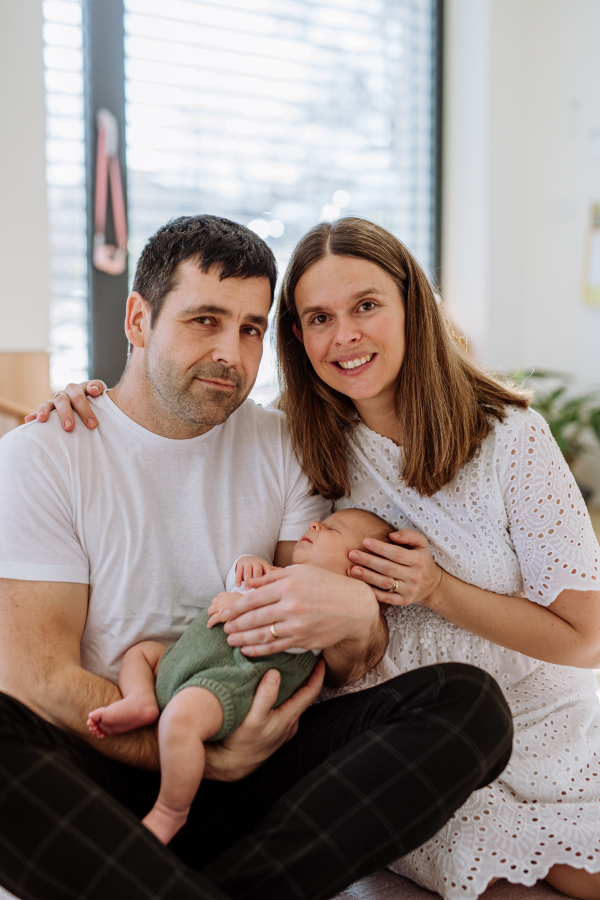 Happy parents cuddling with their newborn son.