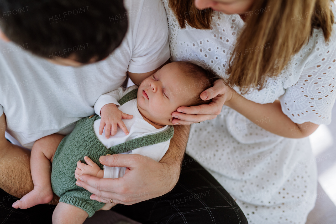 Happy parents cuddling with their newborn son.