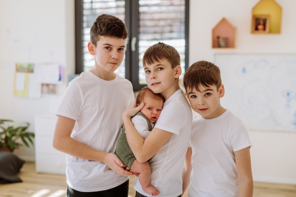 Three big brothers with their newborn brother.