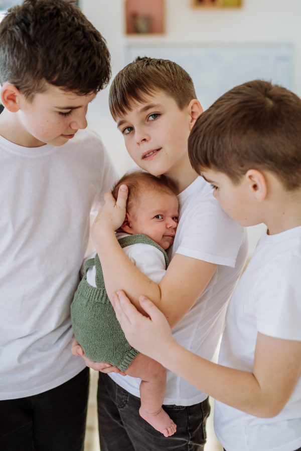 Three big brothers with their newborn brother.