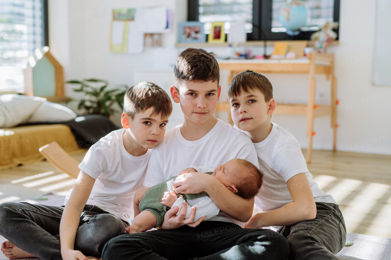 Three big brothers with their newborn brother.