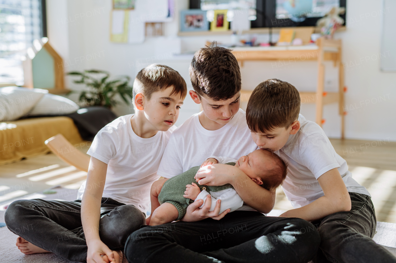 Three big brothers with their newborn brother.