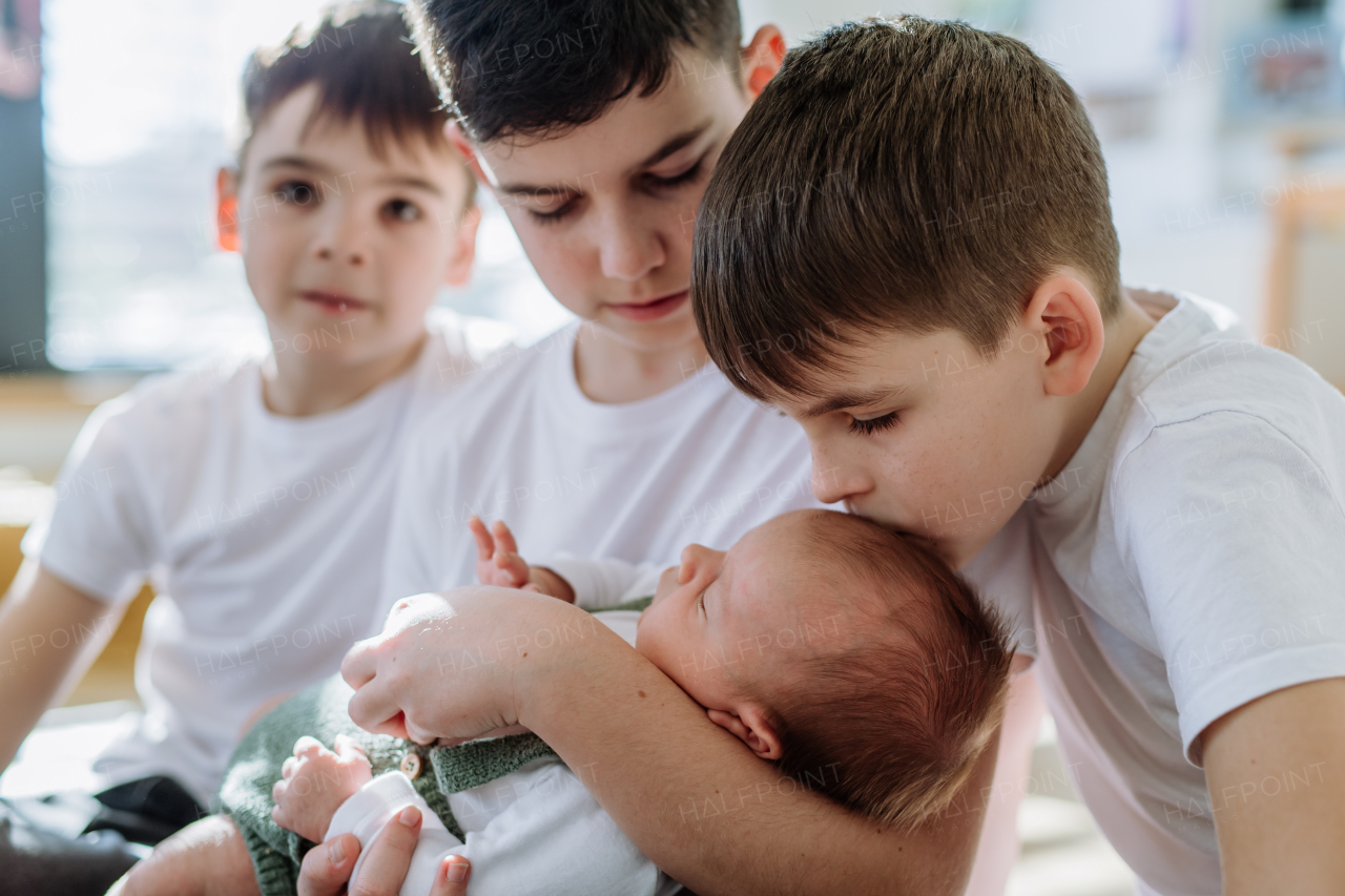 Three big brothers with their newborn brother.