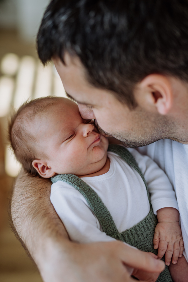 Close-up of father kissing his little new born baby.