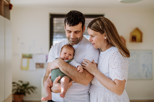 Happy parents cuddling with their newborn son.