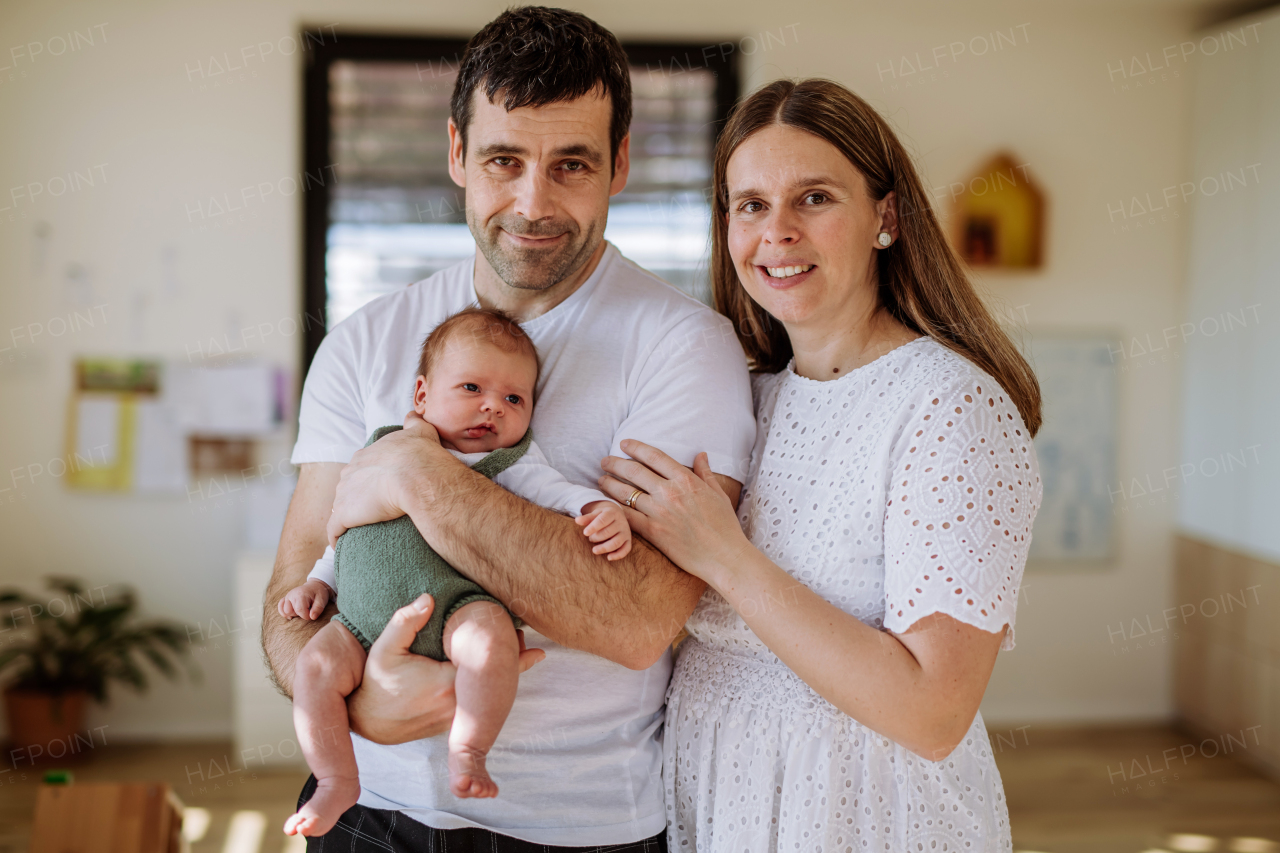 Happy parents cuddling with their newborn son.