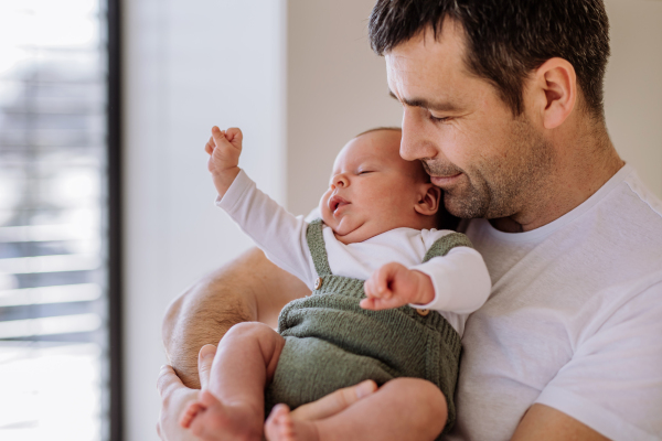 Close-up of father holding his little new born baby.