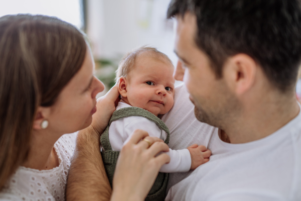 Happy parents cuddling with their newborn son.