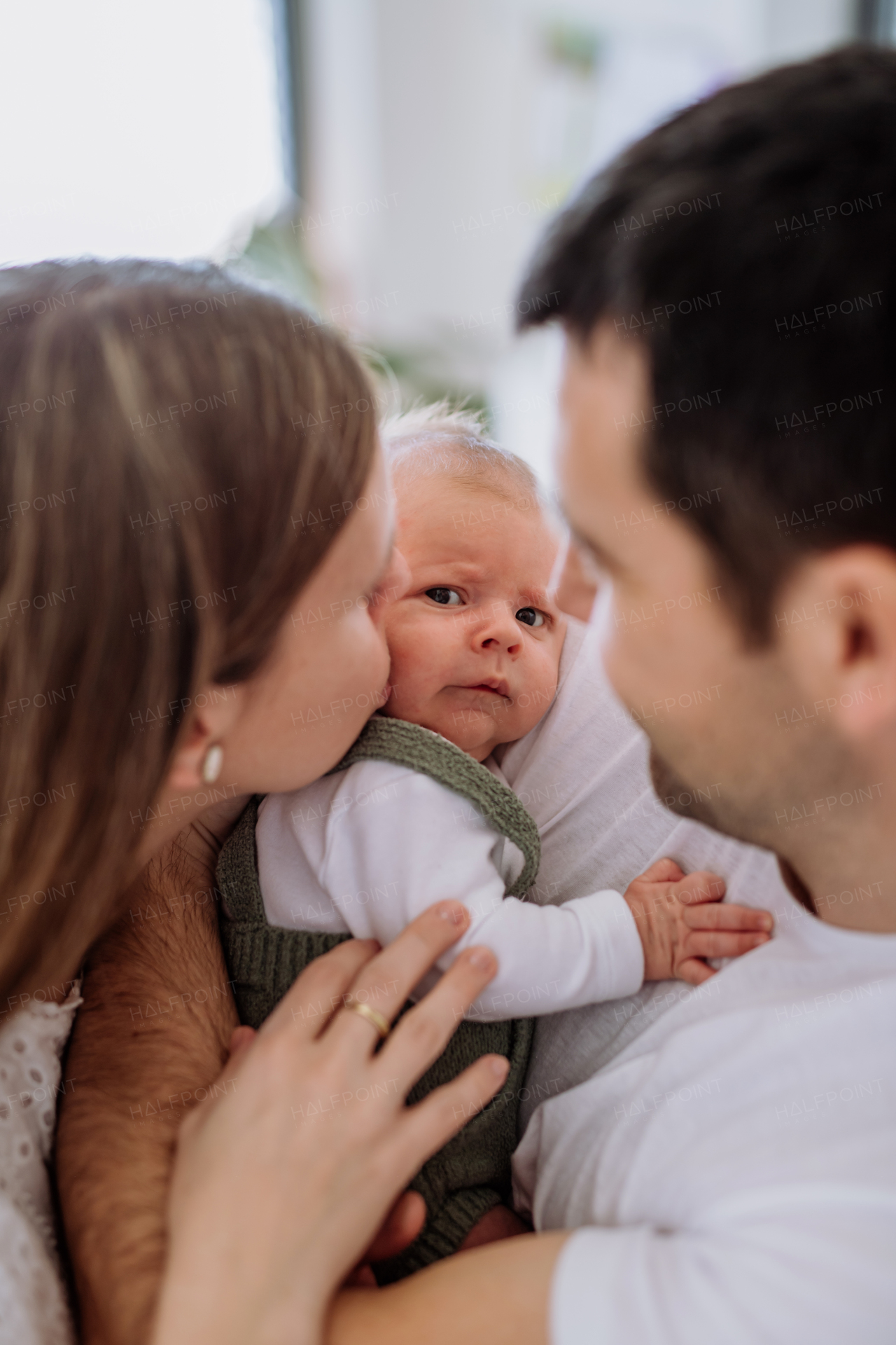 Happy parents cuddling with their newborn son.