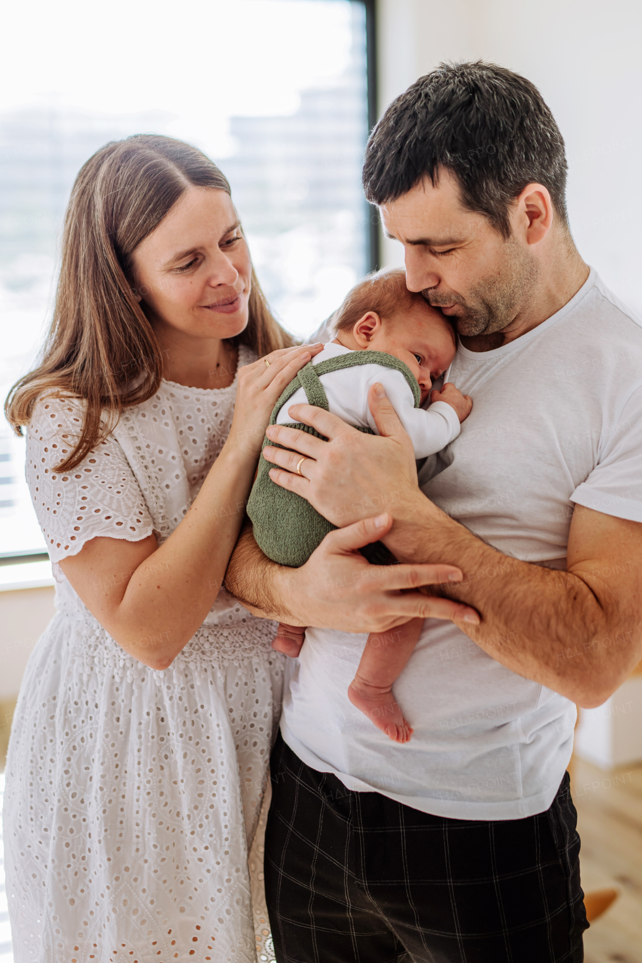 Happy parents cuddling with their newborn son.