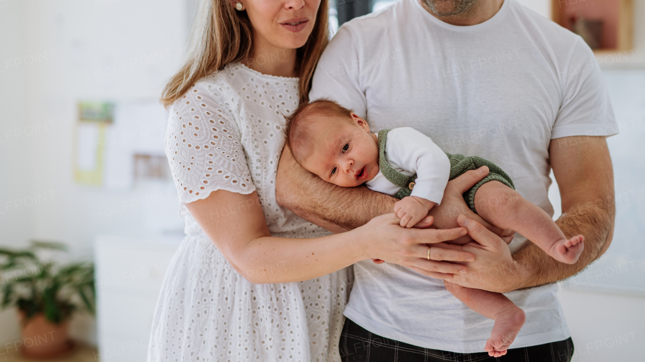 Happy parents cuddling with their newborn son.