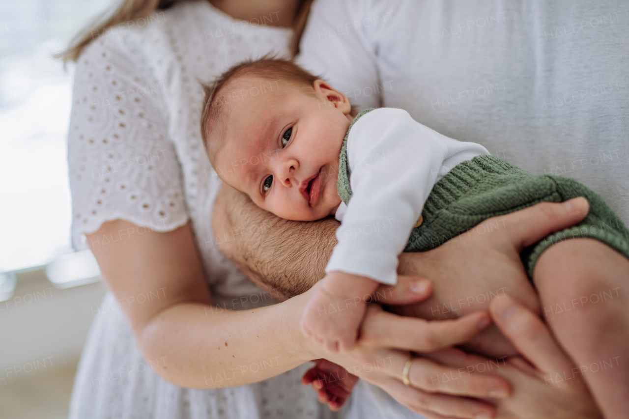 Close-up of parents cuddling with their newborn son.