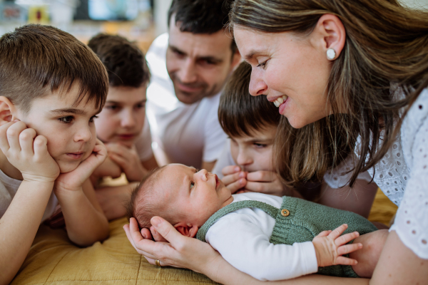 Big family with four sons enjoying their newborn baby.