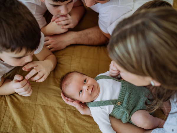 Big family with four sons enjoying their newborn baby.