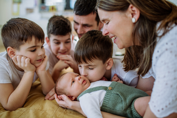 Big family with four sons enjoying their newborn baby.