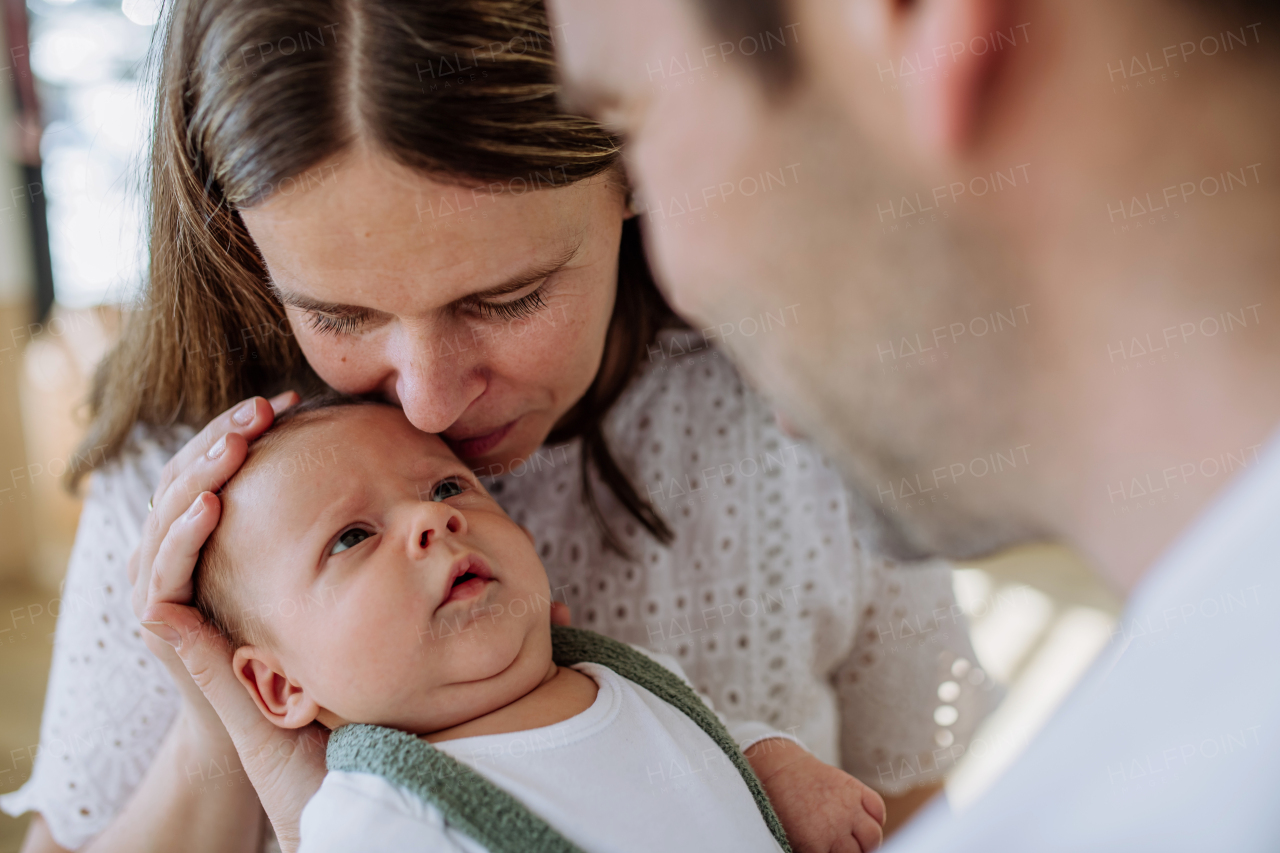 Happy parents cuddling with their newborn son.