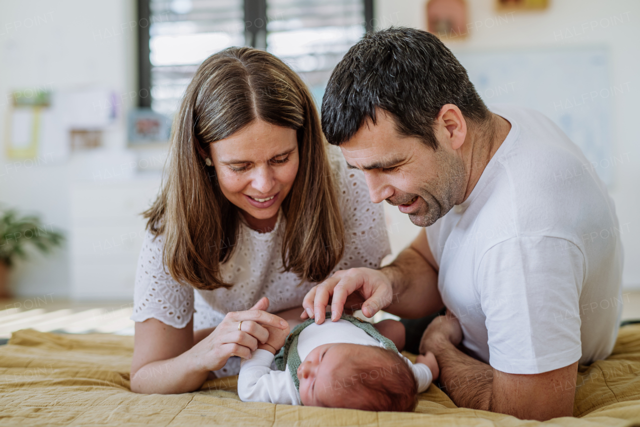 Happy parents cuddling with their newborn son.