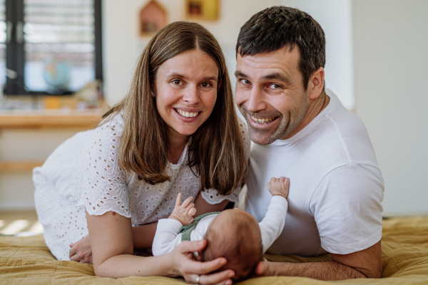 Happy parents cuddling with their newborn son.