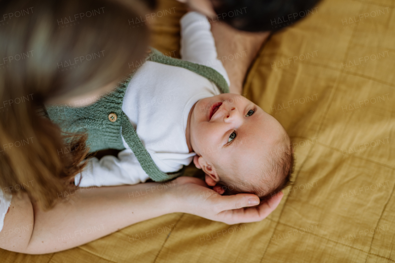 Happy parents cuddling with their newborn son.