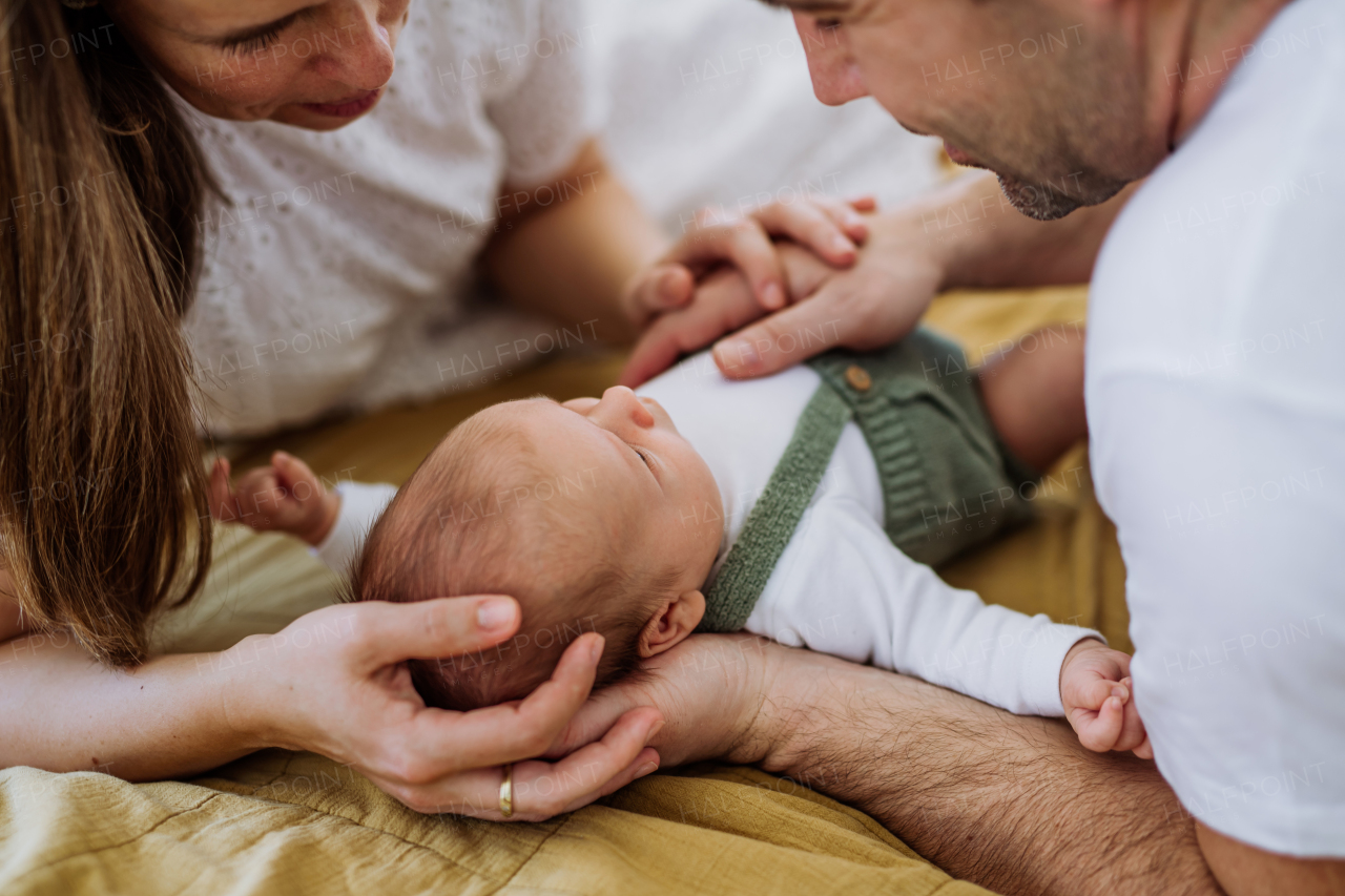 Happy parents cuddling with their newborn son.