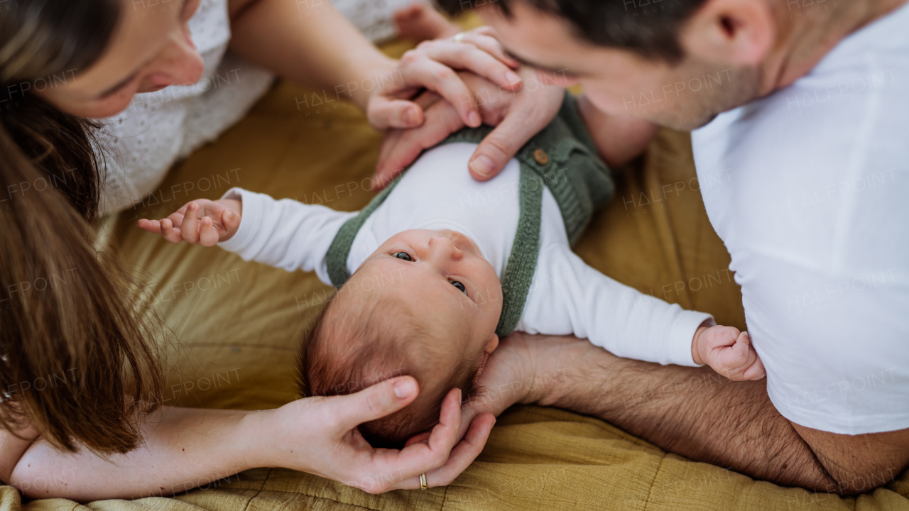 Happy parents cuddling with their newborn son.