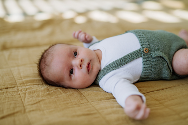 High angle view of sleeping newborn baby in little bed.