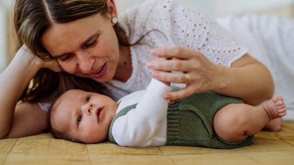 Portrait of woman cuddling her newborn baby.