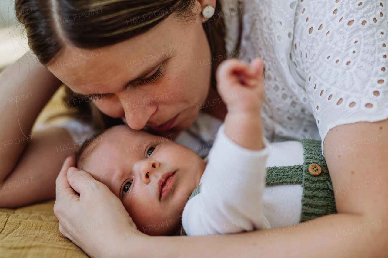 Young mother cuddling with her newborn son.