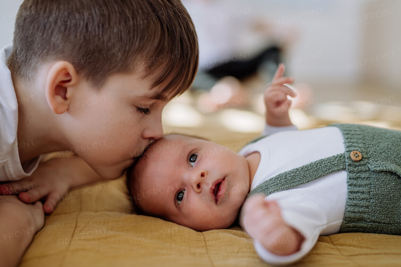 Portrait of a boy kissing his younger brother.