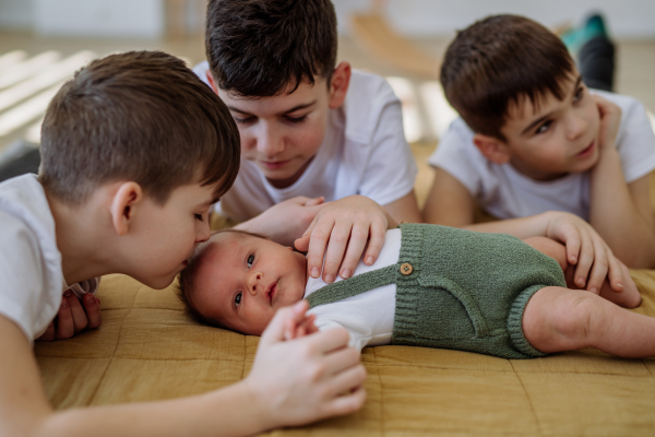 Three big brothers with their newborn brother.