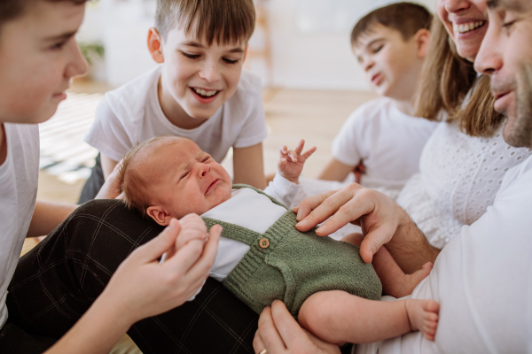 Big family with four sons enjoying their newborn baby.