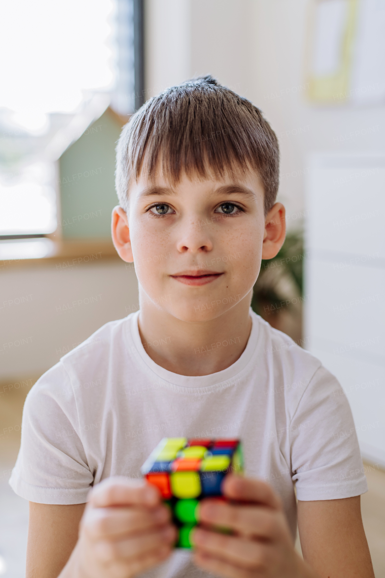 Little boy playing with cube at home.