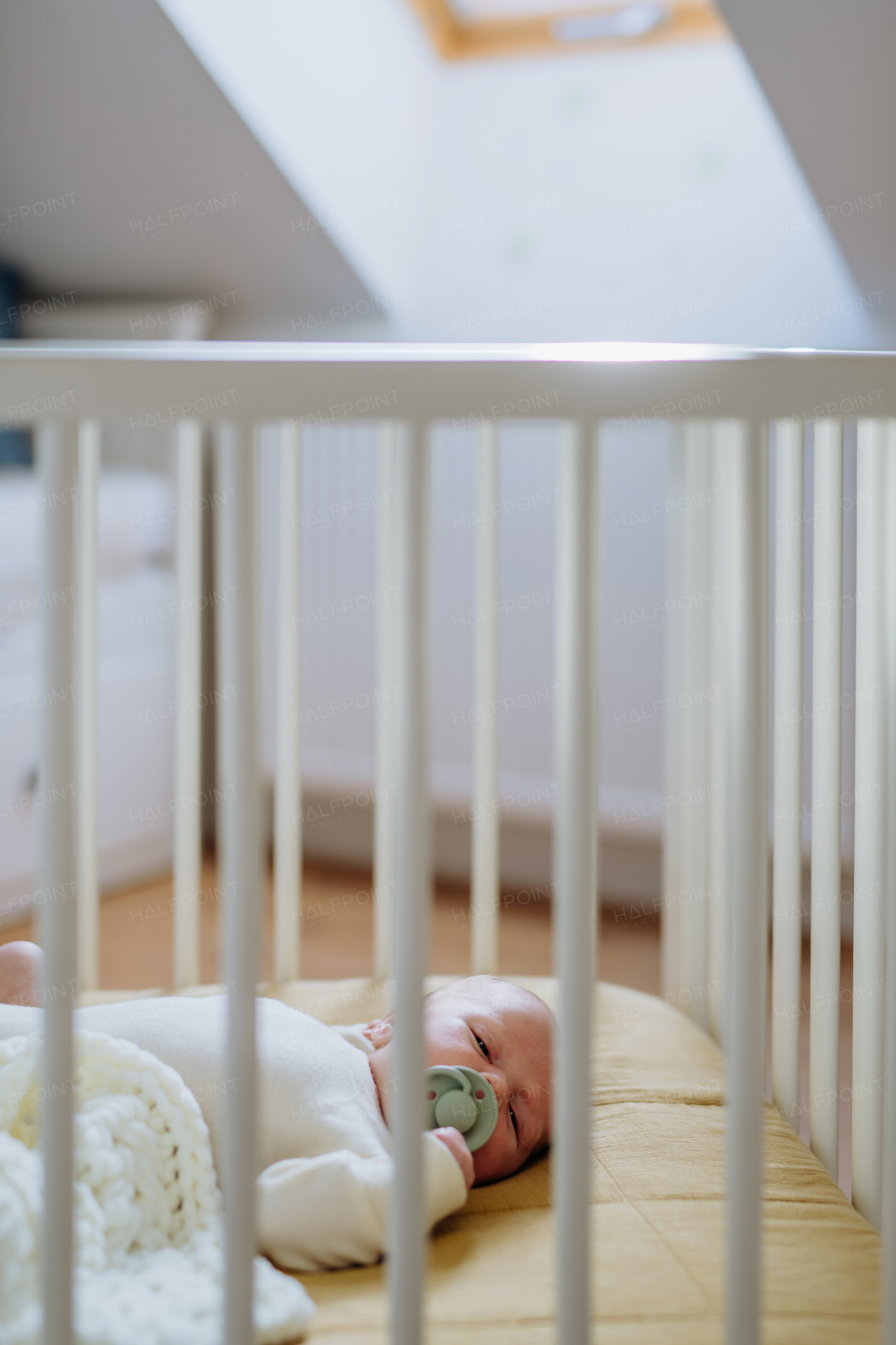 High angle view of newborn baby in little bed.