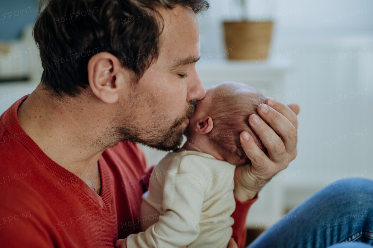 Close-up of father kissing his little new born baby.