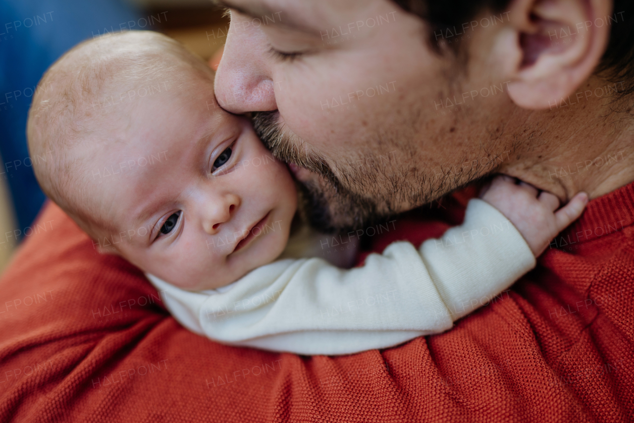 Close-up of father kissing his little new born baby.