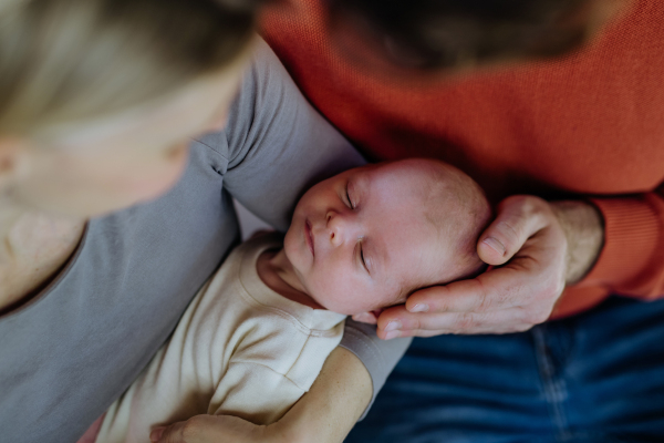 Close-up of parents cuddling their newborn son.