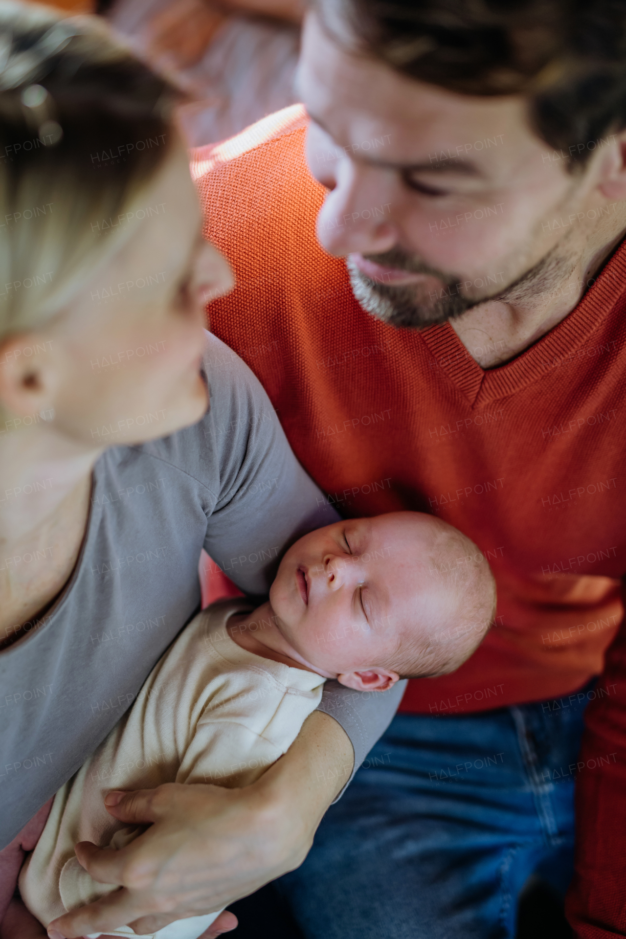 Close-up of parents cuddling their newborn son.