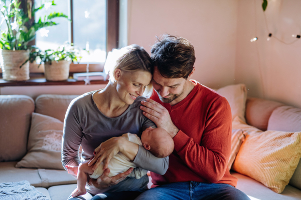 Close-up of parents cuddling their newborn son.