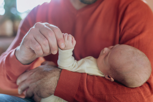 Close-up of father holding his little new born baby.