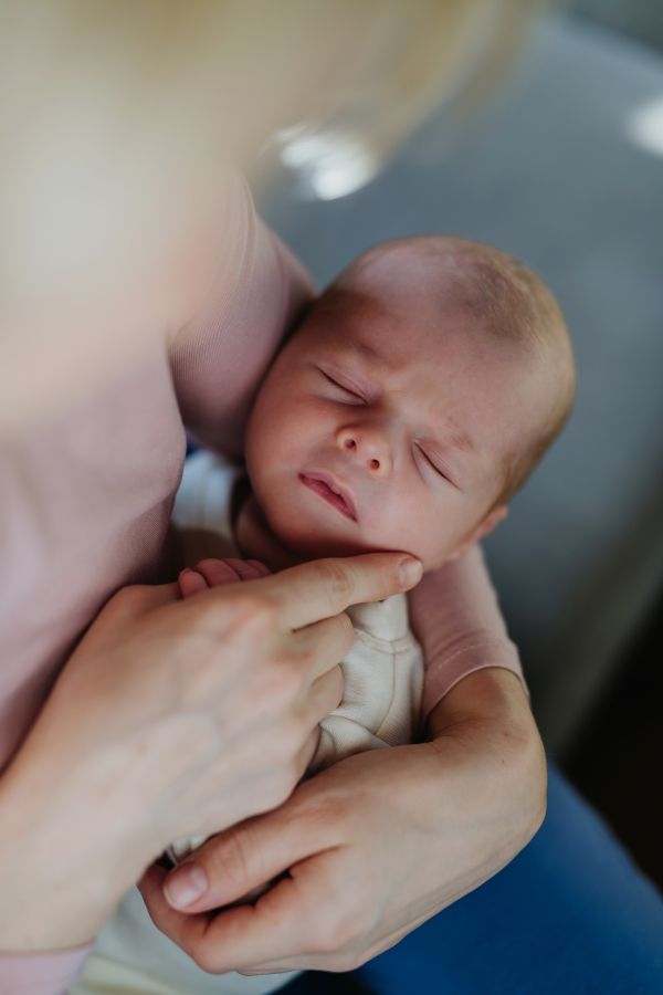 Close-up of mother cuddling with her newborn baby in the bad.