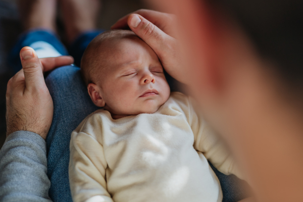 Close-up of father cuddling his little new born baby.