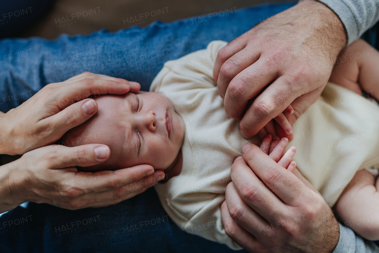 Close-up of parents cuddling their newborn son.