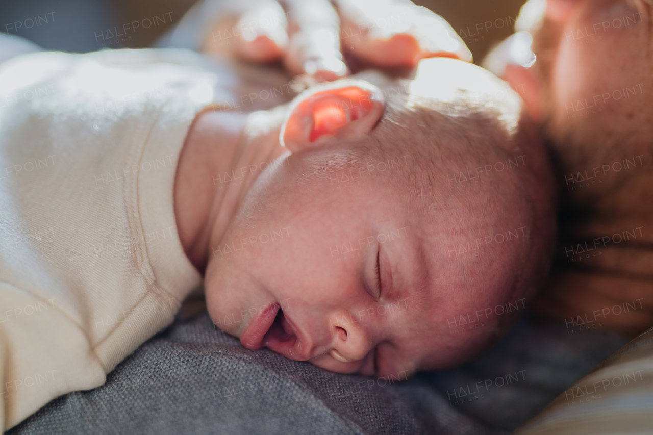 Close-up of father cuddling his little new born baby.