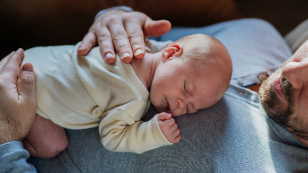 Close-up of father cuddling his little new born baby.