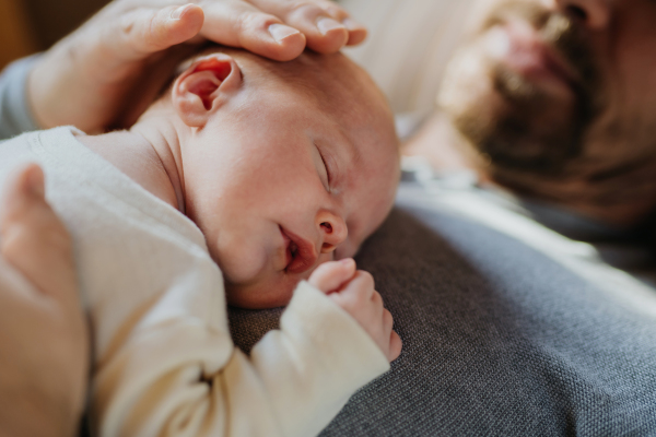 Close-up of father cuddling his little new born baby.